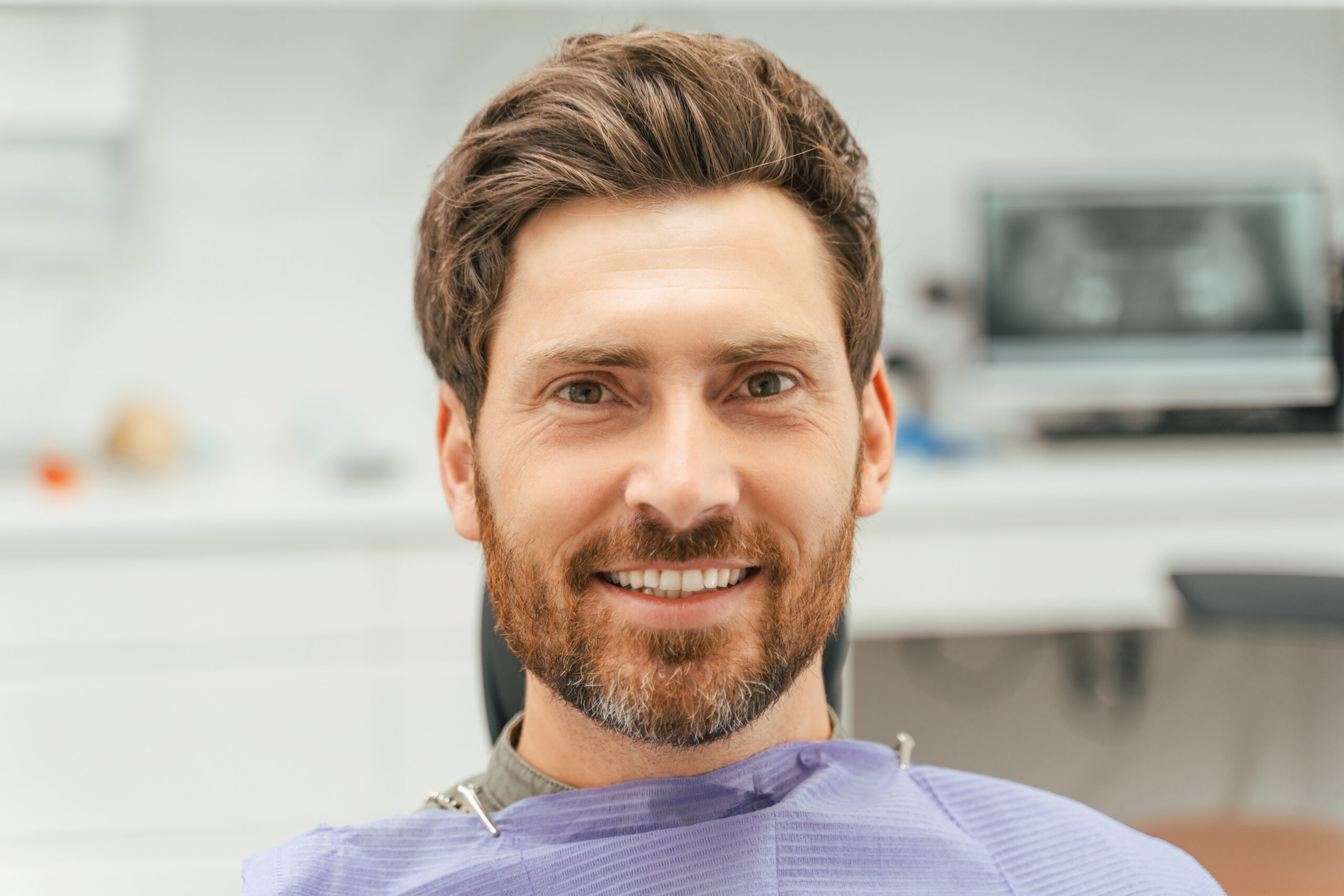Younger, male dental patient smiling with perfect teeth