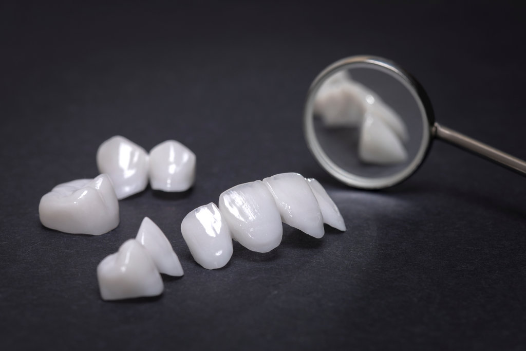 Dental mirror and zircon dentures on a dark background - Ceramic