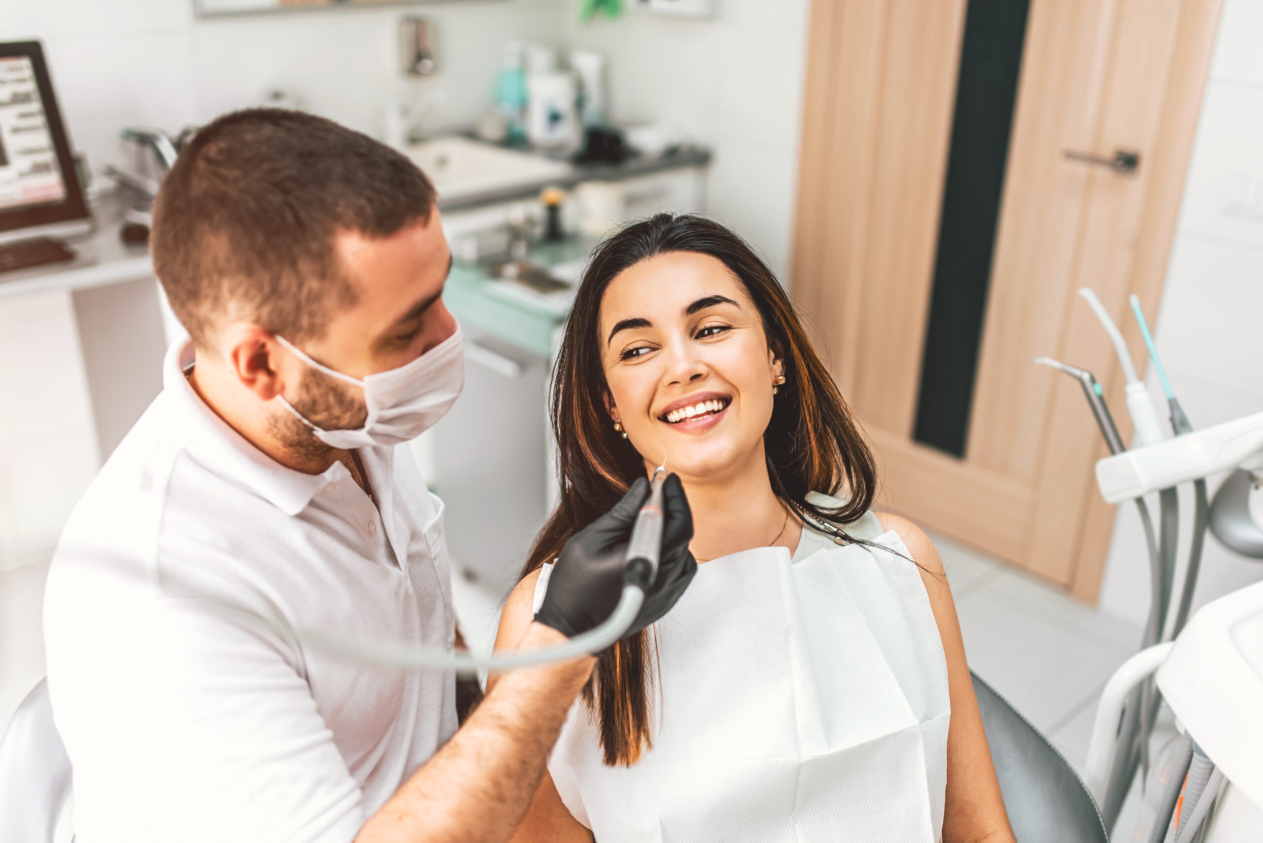 Dentist working in dental clinic with patient in the chair